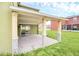Back patio area featuring a sliding glass door entry into the home and green grassy backyard at 2311 Whitley Ln, Winter Haven, FL 33881