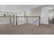 Second floor loft area with light gray walls, plush carpet, and a classic wood railing at 3029 High Pointe St, Clermont, FL 34711