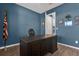 Office space with a dark wood desk, blue walls, and military decor, showcasing a workspace at 3029 High Pointe St, Clermont, FL 34711