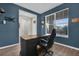 Office space with a large desk, office chair, and window views, featuring a blue accent wall at 3029 High Pointe St, Clermont, FL 34711
