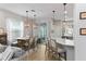 Dining area with modern lighting fixtures, neutral tones and natural light extending to the kitchen at 3173 Riverboat Way, Oviedo, FL 32765