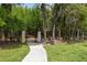 A secure gated entrance provides access to the property, surrounded by mature trees and lush landscaping at 3173 Riverboat Way, Oviedo, FL 32765