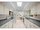 Long kitchen boasts modern appliances, skylight, and eat-in table with view to backyard at 320 Isabella Dr, Longwood, FL 32750