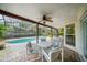 Covered patio featuring a table, chairs, and ceiling fan, with a view of a screened-in pool at 320 Isabella Dr, Longwood, FL 32750