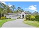 Stunning gray home with a tile roof, three-car garage, and lush landscaping on a circular driveway at 3340 Fernlake Pl, Longwood, FL 32779