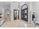 Open foyer with decorative door and views to a side office and the formal dining room, complete with a chandelier at 3340 Fernlake Pl, Longwood, FL 32779