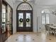 Inviting foyer featuring a decorative front door, tile flooring, and views into the dining room at 3340 Fernlake Pl, Longwood, FL 32779