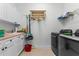 Functional laundry room featuring modern washer and dryer units, utility sink, and ample storage at 3340 Fernlake Pl, Longwood, FL 32779