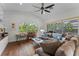 Comfortable living room featuring hardwood floors, a ceiling fan, and a large window with a lush backyard view at 3340 Fernlake Pl, Longwood, FL 32779