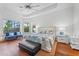 Serene main bedroom with tray ceiling, natural light, and sitting area overlooking the outdoors at 3340 Fernlake Pl, Longwood, FL 32779