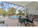 Covered patio with seating area overlooking the screened-in pool and tropical landscaping at 3340 Fernlake Pl, Longwood, FL 32779