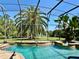 A gorgeous in-ground swimming pool and spa are surrounded by brick and tropical landscaping at 3340 Fernlake Pl, Longwood, FL 32779