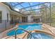 Screened-in pool and patio area with an outdoor spa, safety fence, and string lights at 3340 Fernlake Pl, Longwood, FL 32779
