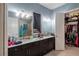 Bright bathroom featuring double vanity, granite counters, large mirror, and direct access to a walk-in closet at 345 Aquamarine Way, Daytona Beach, FL 32124