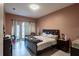 Bedroom with brown walls, tiled floor, a large bed, and natural light streaming through the window at 345 Aquamarine Way, Daytona Beach, FL 32124
