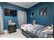 Dark-walled bedroom with a striped bed, a television, and small windows with privacy curtains at 345 Aquamarine Way, Daytona Beach, FL 32124