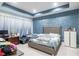 Bedroom with blue accent wall and white curtains, featuring a neutral upholstered headboard at 345 Aquamarine Way, Daytona Beach, FL 32124