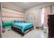 Bright, colorful bedroom with rainbow wall design, tiled floor, and soft natural light at 345 Aquamarine Way, Daytona Beach, FL 32124