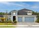 Charming two-story home features a blue exterior, paved driveway, and a three-car garage at 345 Aquamarine Way, Daytona Beach, FL 32124