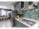 Close up of kitchen features gray cabinets, stainless steel appliances, and a blue tile backsplash at 345 Aquamarine Way, Daytona Beach, FL 32124