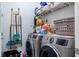 Functional laundry room with modern washer and dryer, storage shelves, and cleaning supplies at 345 Aquamarine Way, Daytona Beach, FL 32124