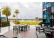 Outdoor seating area with tables and chairs, overlooking a lake and palm trees at 345 Aquamarine Way, Daytona Beach, FL 32124