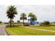 A beautiful community sign for Mosaic nestled between palm trees, landscaping and a view of the lake at 345 Aquamarine Way, Daytona Beach, FL 32124
