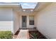 The front entryway with white trim, a storm door, and a small garden at 3748 Innisbrook Dr, Lakeland, FL 33810