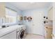 Clean and organized laundry room with modern washer and dryer and storage shelves at 3748 Innisbrook Dr, Lakeland, FL 33810