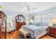 Bright main bedroom with a large bed, wood floors, dresser with mirror and natural light at 3748 Innisbrook Dr, Lakeland, FL 33810