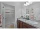 Bathroom featuring double sink vanity, granite countertops, and a sliding door shower at 434 Ironside Trail Dr, Groveland, FL 34736