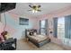 Cozy bedroom featuring pink walls, two windows, carpet floors, and a comfortable bed at 434 Ironside Trail Dr, Groveland, FL 34736