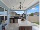 The covered outdoor kitchen features bar seating, a grill, and stone countertops at 434 Ironside Trail Dr, Groveland, FL 34736