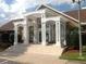 Community clubhouse entrance with white pergola, pillars, and manicured shrubs at 4350 Perkinshire Ln # 108, Orlando, FL 32822