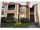 Exterior view of a two-story condo with a walkway and small front yard with orange flowers at 4350 Perkinshire Ln # 108, Orlando, FL 32822