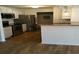 Well-lit kitchen with stainless steel appliances, white cabinets, and wood-look floors at 4350 Perkinshire Ln # 108, Orlando, FL 32822