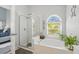 Bright bathroom features separate shower and soaking tub, as well as stained glass window at 442 Troon Cir, Davenport, FL 33897