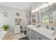 Bright bathroom features double vanity with framed mirrors, a cabinet for towels and storage at 442 Troon Cir, Davenport, FL 33897