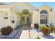 Inviting front porch with welcoming decor, decorative stone, hanging plants, and beautiful landscaping at 442 Troon Cir, Davenport, FL 33897