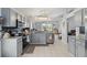 Modern kitchen features stainless steel appliances, gray cabinets, granite counters, and tile flooring at 442 Troon Cir, Davenport, FL 33897