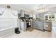 Bright kitchen features stainless steel appliances, gray cabinets, granite counters, and tile floors at 442 Troon Cir, Davenport, FL 33897