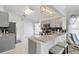 Modern kitchen features gray cabinets, stainless steel appliances, a bar area with stool seating, and tile floors at 442 Troon Cir, Davenport, FL 33897