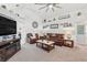Comfortable living room with a fireplace, plush leather furniture, and a ceiling fan at 442 Troon Cir, Davenport, FL 33897