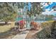 View of a community tennis court surrounded by lush greenery and a secure gate at 442 Troon Cir, Davenport, FL 33897