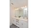 Bathroom with double vanity, ample lighting, a large mirror, and a walk-in shower visible in the reflection at 4751 Clock Tower Dr # 203, Kissimmee, FL 34746