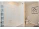 Bright bathroom with a white tiled shower and bathtub combination, a toilet, and neutral decor at 4751 Clock Tower Dr # 203, Kissimmee, FL 34746
