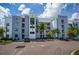 Contemporary building with parking, manicured greenery, balconies, and blue and white accents at 4751 Clock Tower Dr # 203, Kissimmee, FL 34746