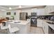 Kitchen featuring stainless steel appliances, white cabinets, a gray backsplash, and a kitchen island with white seating at 4751 Clock Tower Dr # 203, Kissimmee, FL 34746