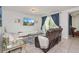 Living room with plush seating, glass coffee tables, a TV, and sliding glass doors to a balcony at 4751 Clock Tower Dr # 203, Kissimmee, FL 34746