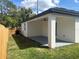 A freshly cut backyard with a covered porch and ceiling fan for outdoor living at 493 E Palmetto Ave, Longwood, FL 32750
